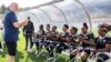 FILE - FIFA president Gianni Infantino talks to players from the Musanze women's amputee football team before launching the women's Amputee Football championship in Rwanda at the Pele Stadium in Kigali, Rwanda, March 16, 2023.