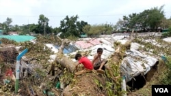 বাংলাদেশের কক্সবাজারে রোহিঙ্গা শরণার্থী শিশুরা ঘূর্ণিঝড় মোকার পরে তাদের আশ্রয়কেন্দ্রের ধ্বংসাবশেষের মধ্যে একটি অস্থায়ী খেলার মাঠ তৈরি করে। (মোঃ জামাল/ ভয়েস অফ আমেরিকা) 