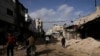 Warga Palestina berjalan di jalan rusak pasca operasi tentara Israel di kamp pengungsi Jenin, Tepi Barat, Minggu, 26 November 2023. (Foto: AP)