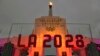 FILE - An LA 2028 sign is seen in front of the Olympic cauldron at the Los Angeles Memorial Coliseum, Sept. 13, 2017. 