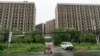 FILE - A rider passes by an abandoned construction project on the outskirts of Beijing, July 25, 2024. 