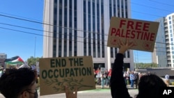 Para pengunjuk rasa pro-Palestina meneriakkan slogan-slogan di luar Konsulat Israel di Atlanta, 8 Oktober 2023. Seorang pengunjuk rasa yang membawa bendera Palestina membakar diri luar gedung itu pada Jumat, 1 Desember 2023. (Foto: Jeff Amy/AP Photo)