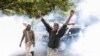 Kenyan activists shout amidst teargas during a protest over tax hike plans in Nairobi on June 6, 2023. 