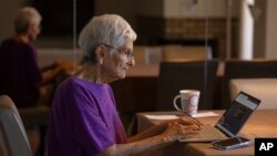 FILE - Barbara Winston uses a computer at her home in Northbrook, Ill., on June 30, 2024, several days after taking an introduction to artificial intelligence class at a local senior center.