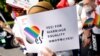 FILE— A participant holds a sign as they march during the Tokyo Rainbow Pride parade, celebrating advances in LGBTQ rights and calling for marriage equality, in Tokyo, Japan April 23, 2023. 
