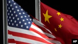 FILE - The U.S. and Chinese flags wave ahead of the 2022 Winter Olympics, in Zhangjiakou, China, Feb. 2, 2022. Beijing on Aug. 25, 2024, protested U.S. sanctions on firms Washington says enable Moscow to continue its Ukraine offensive.