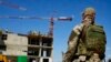 FILE - Seorang tentara Rusia menjaga lokasi gedung apartemen baru yang sedang dibangun dengan dukungan Kementerian Pertahanan Rusia, di Mariupol, di wilayah yang berada di bawah kendali Pemerintah Republik Rakyat Donetsk, Ukraina timur, 13 Juli 2022. (AP)