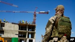 FILE - Seorang tentara Rusia menjaga lokasi gedung apartemen baru yang sedang dibangun dengan dukungan Kementerian Pertahanan Rusia, di Mariupol, di wilayah yang berada di bawah kendali Pemerintah Republik Rakyat Donetsk, Ukraina timur, 13 Juli 2022. (AP)