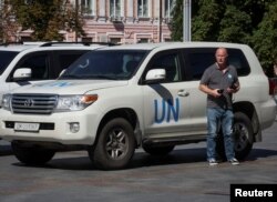 Seorang anggota misi Badan Energi Atom Internasional (IAEA), yang akan mengunjungi pembangkit listrik tenaga nuklir Zaporizhzhia, berdiri di dekat kendaraan PBB di dekat sebuah hotel di pusat Kyiv, 30 Agustus 2022. (Foto: Reuters)