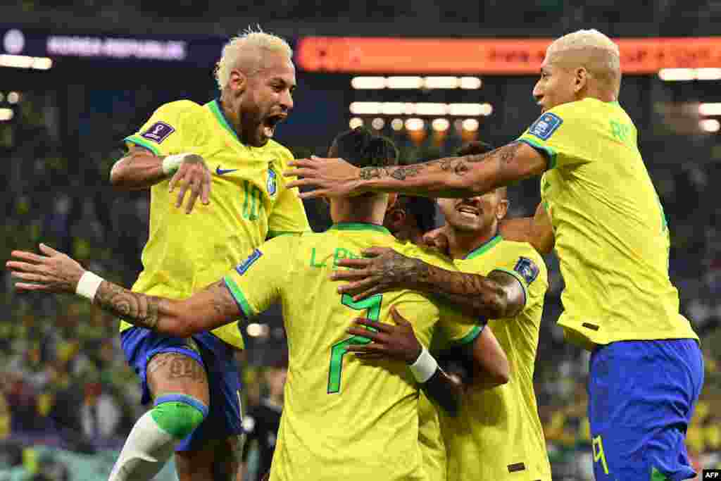 Attaquant ya Brésil #20 Viniciux Junior (C) azali kosepaela elonga na baninga ba ye ba ekipi nsima na kotia mongete ya mibale na Corée du Sud na 7e ya Mondial Qatar 2022. stade 974, Doha, 5 décembre 2022. (Photo by MANAN VATSYAYANA / AFP)