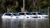 Tiga mobil terjebak banjir di Shepparton, Australia, Senin, 17 Oktober 2022. (Diego Fedele/AAP via AP)