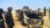 Wani dan sanda yana duba gine gine da ababan hawa da kuma makamai bayan harin da kungiyar Boko Haram ta kai a Damaturu ranar 25 da 25 ga watan Oktoba. An dauki hotunan ranar 28 ga watan Oktoba, 2013.