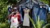 Les agents de santé à un point de passage non annoncé au journal officiel dans le village de Mirami, près du point de contrôle à la frontière de Mpondwe entre l'Ouganda et la République démocratique du Congo, le 14 juin 2019.