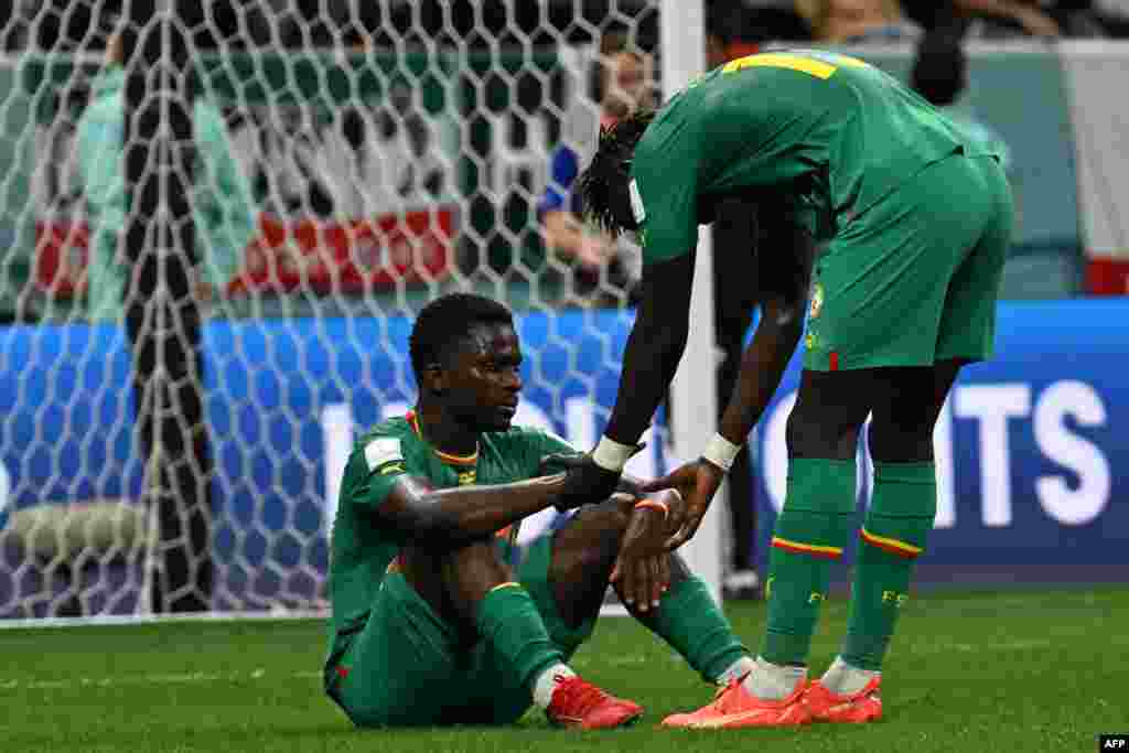 Attaquant ya Sénégal #19 Famara Diedhiou azali kolendisa attaquant ya Sénégal mosusu #20 Bamba Dieng nsima bolongwi na bango na kopola 0-3 lliboso lya Angleterre na Mondial Qatar 2022 na stade Al-Beytm Dohar, 4 décembre 2022. (Photo by Pablo PORCIUNCULA