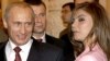 Presiden Rusia Vladimir Putin tersenyum saat melihat ke arah pesenam Rusia Alina Kabaeva dalam pertemuan dengan tim Olimpiade Rusia di Kremlin, Moskow, 4 November 2004. (Foto: Reuters/ITAR-TASS/Presidential Press Service)
