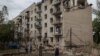 Sejumlah warga lokal mengamati gedung perumahan warga yang hancur akibat serangan pasukan Rusia di Kota Chasiv Yar, wilayah Donetsk, Ukraina, pada 11 Juli 2022. (Foto: Reuters/Gleb Garanich)