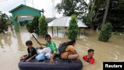 Sejumlah warga menggunakan kasur untuk mengevakuasi kerabat mereka menyusuk banjir yang melanda wilayah Lhoksukon, Aceh Utara, pada 3 Januari 2022. (Foto: Antara via Reuters/Rahmad)