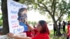 Cynthia Moreno, 32, menempelkan flyer di seberang jalan dari kantor Imigrasi dan Bea Cukai AS pada 15 Juni 2022, di Miramar, Amerika. (Foto: AP)