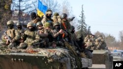 Українські військові їдуть на танку через місто Тростянець 28 березня 2022 р. (Фото AP/Єфрем Лукацький, файл)
