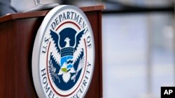 Logo dari Departemen Keamanan dalam Negeri AS terlihat terpasang pada sebuah mimbar di Bandara Internasional Miami, pada 20 November 2020. (Foto: AP/Lynne Sladky)