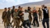 Sejumlah tentara Israel bentrok dengan warga Palestina dalam demo yang menentang penggusuran desa-desa warga Palestina di Hebron, Tepi Barat, pada 22 Juni 2022. Pihak Israel menggusur desa-desa tersebut untuk membuat zona latihan militer bagi tentaranya. (Foto: AFP/Mosab Shawer)