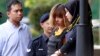 Vietnamese suspect Doan Thi Huong, second from right, in the ongoing assassination investigation, is escorted by police officers out from Sepang court in Sepang, Malaysia on Wednesday, March 1, 2017. Appearing calm and solemn, two young women accused of smearing VX nerve agent on Kim Jong Nam, the estranged half brother of North Korea's leader, were charged with murder Wednesday. (AP Photo/Daniel Chan) 