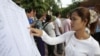 A woman finds her name on a list during a local commune election in Phnom Penh, Cambodia.