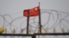 资料照：中国新疆喀什以南的一处围墙铁丝网后的中国国旗。（2019年6月4日）
