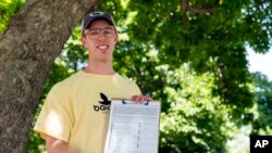 FILE - Nate Golden, president of the Maryland Child Alliance, poses for a portrait with a petition form for the Baltimore Baby Fund, July 3, 2024, in Baltimore. 