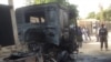 Policemen stand guards at a burnout truck following an attacked by Boko haram militants near an Air force base in Maiduguri, December 2. 2013. 