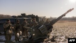 Українські військові біля зенітної автоматичної гармати, яку використовують для прицілювання на російські безпілотники, 30 листопада 2023 року. (Photo by Roman PILIPEY / AFP)
