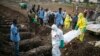 FILE - Health workers carry the body of an Ebola victim for burial Dec. 17, 2014, at a cemetery in Freetown.