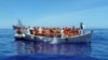 Migrants sit in their boat during a rescue operation by the Italian navy off the coast of Sicily in this handout picture from the Italian Marina Militare, released May 6, 2016. Italy's coast guard rescued about 1,000 people off the country's southern tip Thursday.