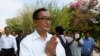 Cambodian main opposition Cambodia National Rescue Party leader Sam Rainsy, front, greets his supporters as his arrives at Choeung Ek memorial on the outskirts of Phnom Penh, Cambodia, Friday, May 17, 2015.