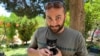 Jurnalis visual Reuters Issam Abdallah tampak memegang kucing dalam sebuah foto yang diambil di Saaideh, Lebanon, pada 4 Juli 2023. Abdallah tewas dibunuh oleh tentara Israel ketika meliput area perbatasan Israel-Lebanon. (Foto: Reuters/Emilie Madi)