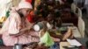FILE- A mother feeds her malnourished child at a feeding center run by Doctors Without Borders in Maiduguri, Nigeria, Aug. 29, 2016.