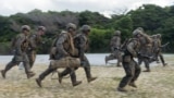 美国海军陆战队士兵在日本冲绳汉森营进行机枪架设演练，为“坚决之龙25”演习做准备。(2025年9月9日)