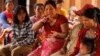 In this Feb. 26, 2015 photo, Kop Let, center, from the indigenous Bunong tribe, speaks during an interview with The Associated Press in Bousra commune, Mondulkiri province, in eastern Cambodia. Kop Let, who is the wife of a village chief, says she struggles to feed her extended 17-member family after the Socfin-KCD plantations swallowed most of the family’s 12 hectares (30 acres). (AP Photo/Heng Sinith)