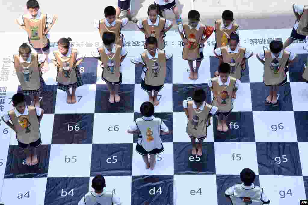 河北省邯郸市农林路小学的学生比赛&quot;真人国际象棋&quot;（2017年6月19日），装扮成&quot;王、后、车、象、马、兵&quot;的&quot;棋子&quot;，在大型棋盘上变换位置。