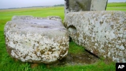 In this photo provided by researchers in August 2024, Stonehenge's "altar stone" lies underneath two Sarsen stones in Wiltshire, England. (Aberystwyth University via AP)