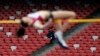 FILE - A security guard watches as a Russia athlete, front, makes an attempt at the women's high jump during the 2014 IAAF World Challenge Beijing held at China's National Stadium in Beijing, May 21, 2014. 