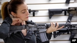 A gun shop owner demonstrates a Ruger AR-15 semi-automatic rifle, Nov. 7, 2017, in Lynnwood, Wash.