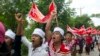 Myanmar factory workers hold placards which read "To get at least 4,000 kyat a day," as they stage a rally in Hlaingtharyar township, in suburb of Yangon, Myanmar, July 12, 2015.