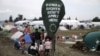 FILE - A banner placed by activists is seen on a street sign at a makeshift camp for refugees and migrants at the Greek-Macedonian border, near the village of Idomeni, Greece, March 17, 2016.