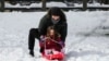 Una mujer juega con su hija en un trineo de nieve en el Parque Central de Nueva York el 13 de febrero de 2024.