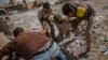 A fighter of the Libyan forces affiliated to the Tripoli government is helped by comrades after being shot by a sniper, in Sirte, Libya, Oct. 2, 2016. 