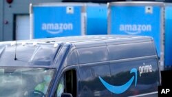 FILE - An Amazon Prime logo appears on the side of a delivery van as it departs an Amazon warehouse location in Dedham, Massachusetts, Oct. 1, 2020.