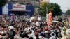 Cambodia's factory workers and members of the country's main opposition Cambodia National Rescue Party, cheer as opposition leader Sam Rainsy arrived at a street near Freedom Park in Phnom Penh, Cambodia, Thursday, May 1, 2014. 