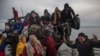 Migrants disembark from a small boat after their arrival from the Turkish coast on the northeastern Greek island of Lesbos, Nov. 16, 2015. Greek authorities say 1,244 migrants have been rescued in the past three days.