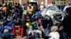Refugees and migrants sit next to their belongings before boarding a bus heading to other parts of the country where they will be accommodated, at the port of Piraeus, near Athens, Greece, March 31, 2016.